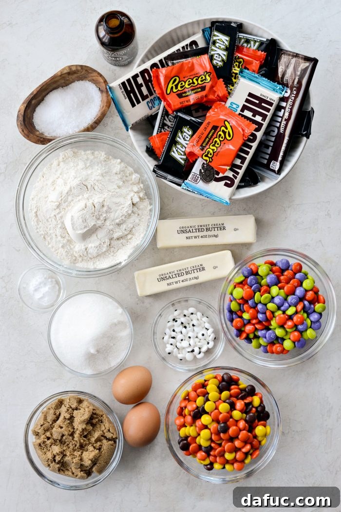 Halloween Haul Cookie Bars 4 A collection of essential ingredients for Halloween Candy Cookie Bars, including various flours, sugars, butter, eggs, and an assortment of colorful candies.