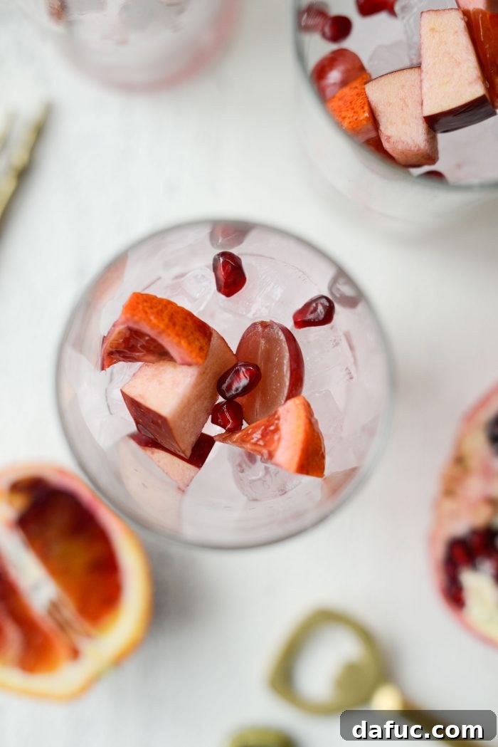 Ruby Fizz Sangria 16 Glasses being filled with ice and fruit for sangria