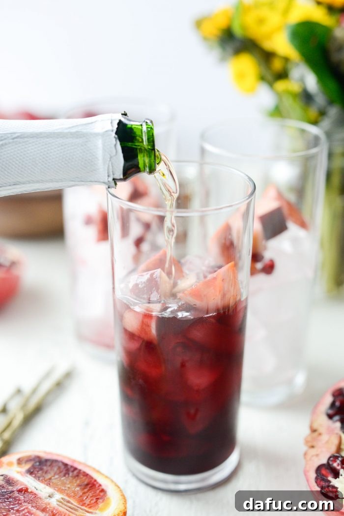 Topping off a glass of sangria with sparkling apple cider