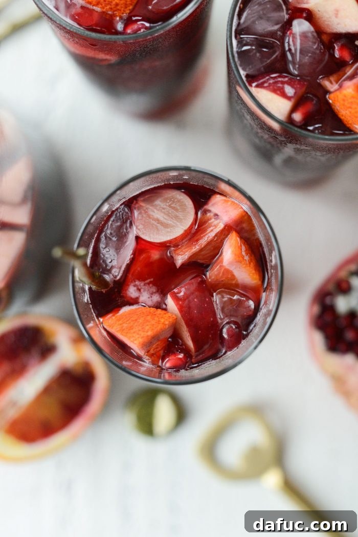 Ruby Fizz Sangria 23 A glass of Pomegranate Sparkling Apple Cider Sangria, partially consumed, showing enjoyment