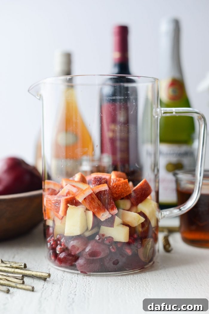 Ruby Fizz Sangria 7 Grapes, pomegranate arils, apples, and blood oranges in a glass pitcher