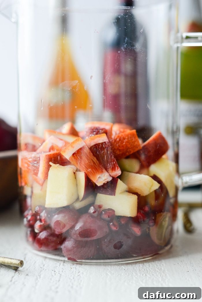Close-up of colorful fresh fruit inside a glass pitcher, ready for sangria liquids