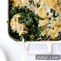 Close-up of a serving of Creamy Spinach Gratin, showing its golden-brown cheese topping and tender spinach.