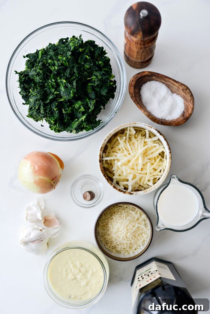 All the fresh ingredients laid out for making Spinach Gratin, including spinach, onions, garlic, cheeses, and spices.