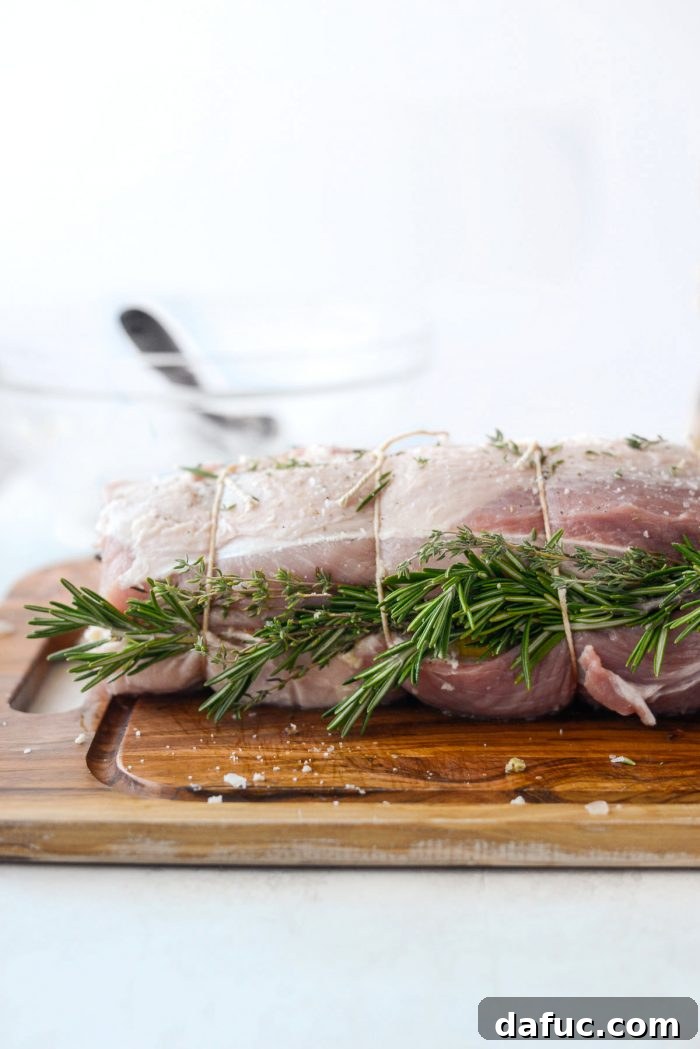 Sweet Pear, Savory Bacon, and Tangy Blue Cheese Stuffed Pork Loin 12 Fresh herbs tucked under kitchen string on a tied pork loin