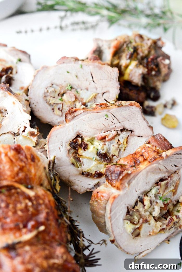 Sweet Pear, Savory Bacon, and Tangy Blue Cheese Stuffed Pork Loin 19 Close-up of a delicious slice of stuffed pork loin with cranberry sauce