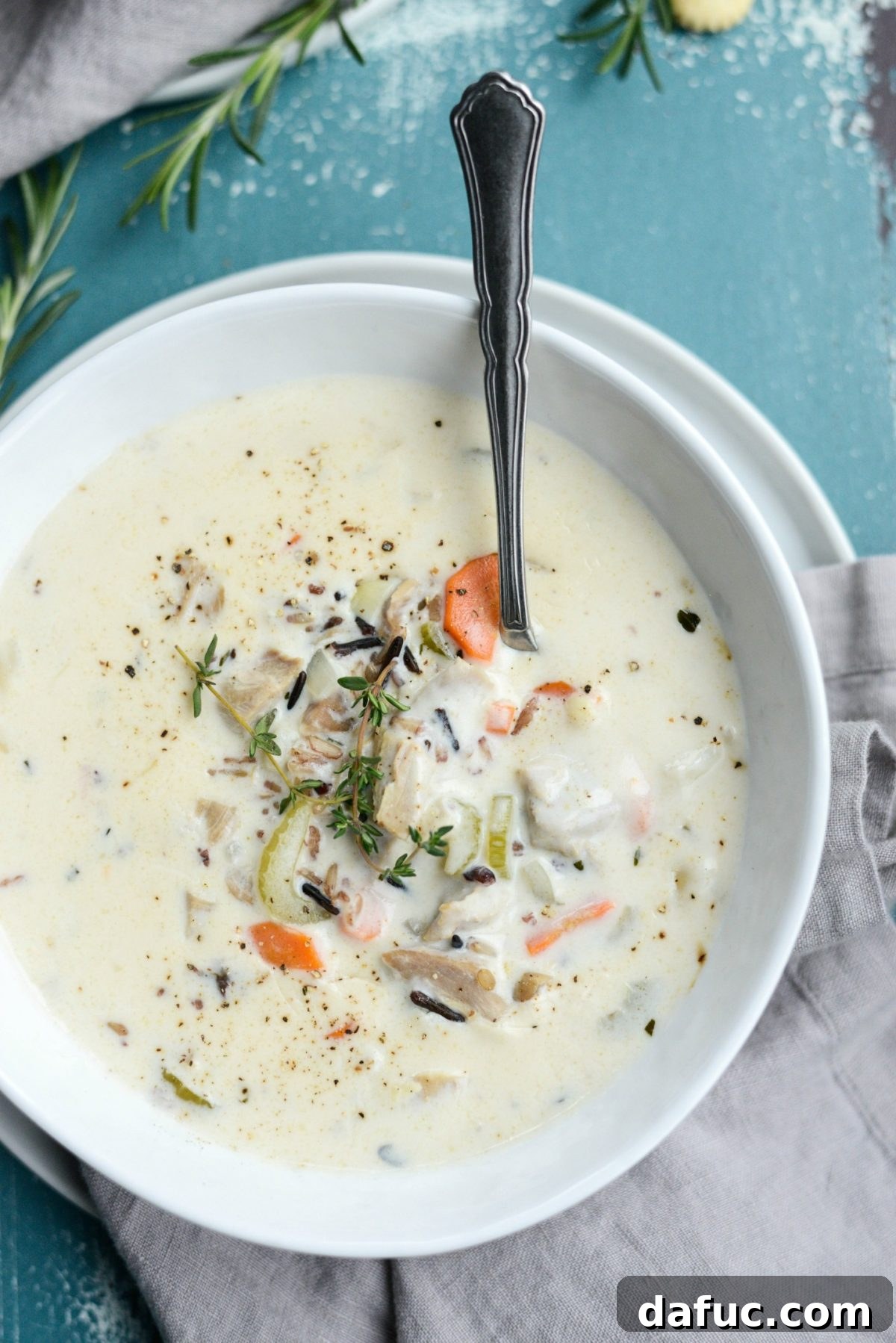 A hearty and earthy bowl of Homemade Turkey Wild Rice Soup, featuring tender turkey, perfectly cooked wild rice, fresh vegetables, and herbs in a luxurious creamy broth.
