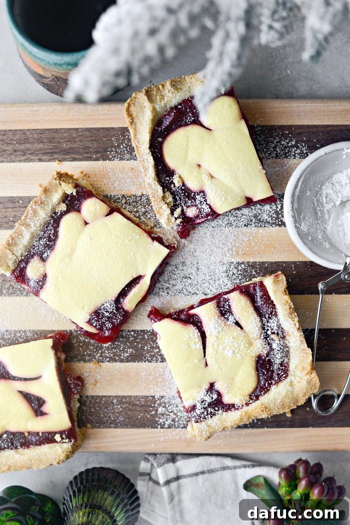 Perfectly cut squares of Cranberry Küchen, a simple yet delicious German-inspired dessert featuring a cookie-like crust, vibrant cranberry filling, and a creamy sour cream topping.