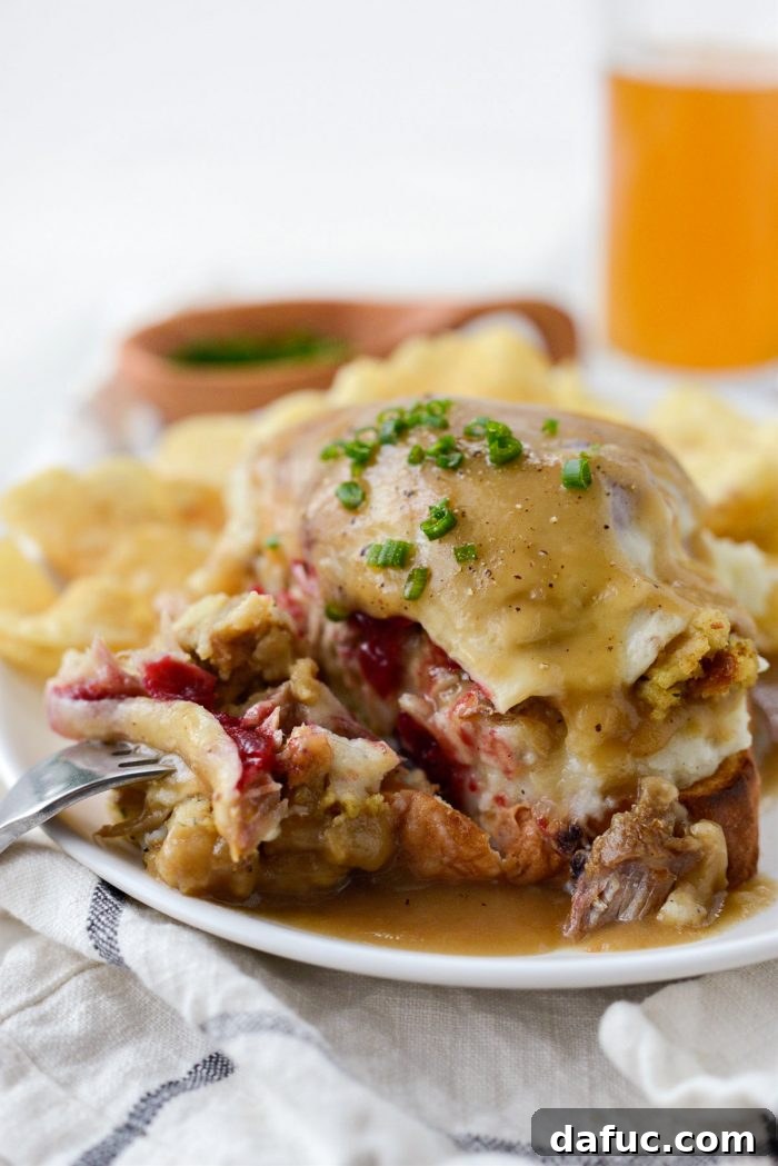 Two open-faced Leftover Thanksgiving Turkey Dinner Melts, piled high with turkey, stuffing, mashed potatoes, melted cheese, and smothered in gravy on Texas toast.