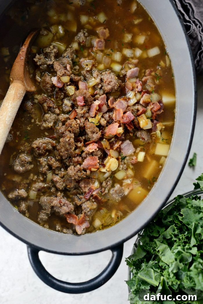 Cooked bacon, sausage, and onions being added back into the soup with the potatoes.