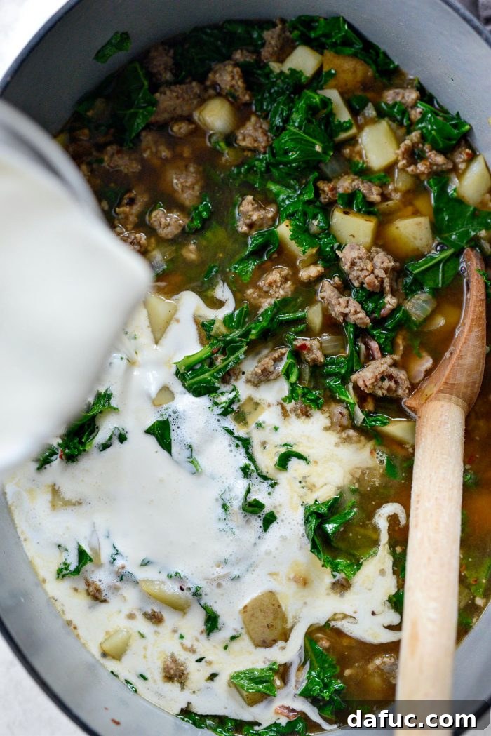 Heavy cream being poured into the Zuppa Toscana soup.
