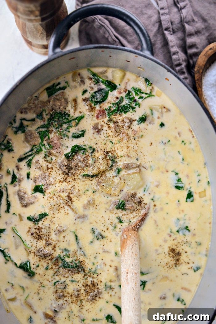 Seasoning the Zuppa Toscana with kosher salt and black pepper to taste.
