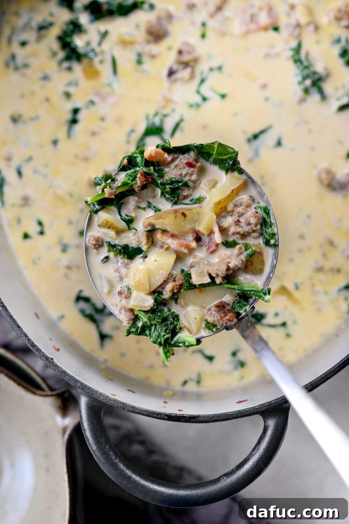 A ladle scooping a portion of Zuppa Toscana soup from the pot.