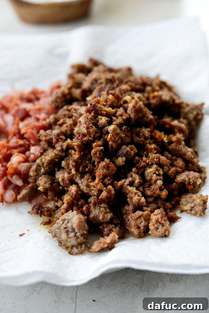 Cooked browned sausage on a plate with crispy bacon.