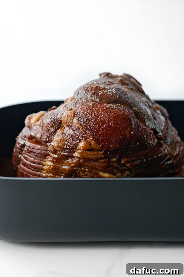 Jeweled Pomegranate Bourbon Glazed Ham 14 The ham in the roasting pan, uncovered and coated with glaze, after baking for the first 15 minutes of the glazing process.