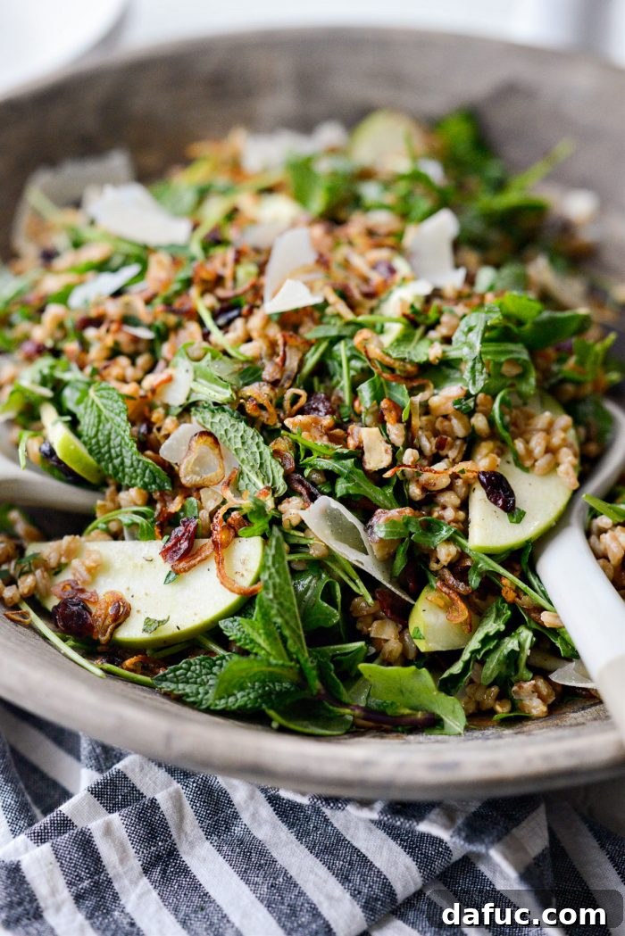 A close-up of the garnished Winter Farro Salad, featuring the crispy fried shallots and fresh herb sprinkles, inviting a closer look.