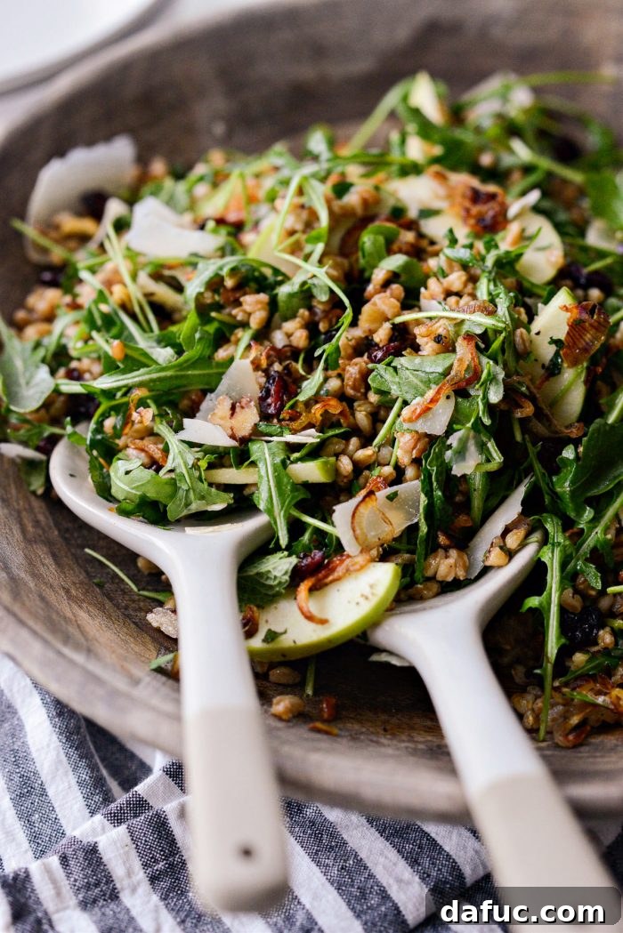 Close-up of the Winter Farro Salad ingredients, highlighting the cooked farro, vibrant green apples, and ruby red dried cranberries.