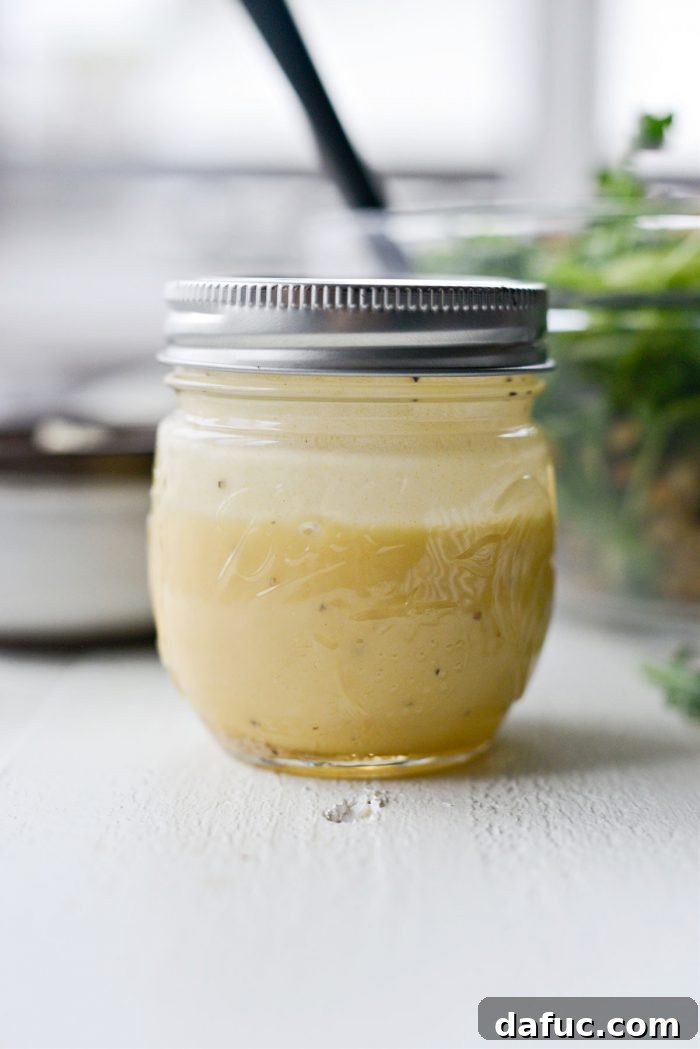 Honey Dijon dressing, perfectly emulsified and shaken, ready to be poured over a delicious salad.