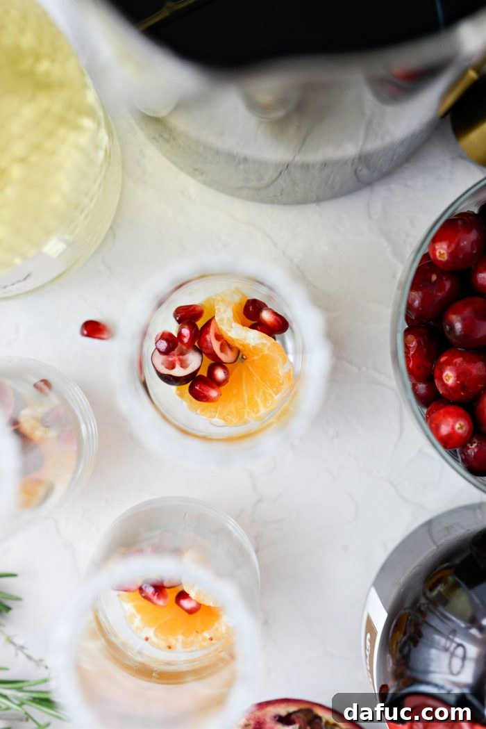 Bright & Bubbly Christmas Mornings 11 Champagne glass with clementine slice, cranberry halves, and pomegranate arils as garnish