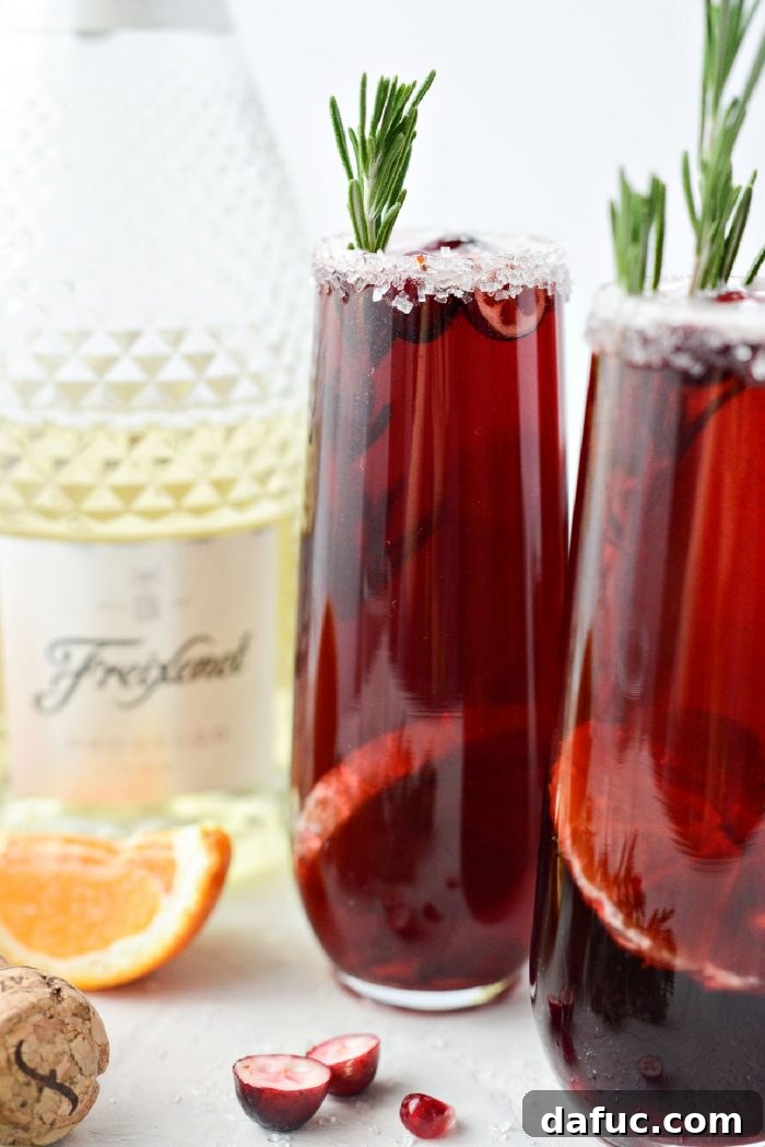 Bright & Bubbly Christmas Mornings 16 A beautifully garnished glass of Christmas Morning Mimosa with a sprig of rosemary