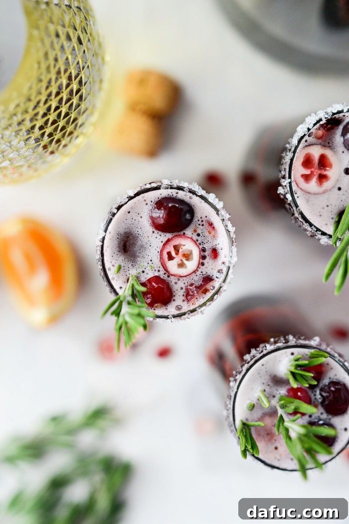 Bright & Bubbly Christmas Mornings 18 Overhead view of Christmas Morning Mimosas garnished with cranberries and pomegranate seeds, showcasing vibrant colors