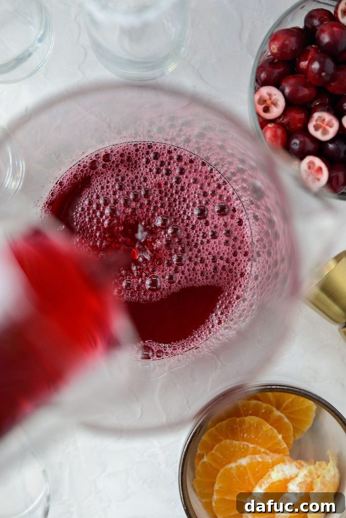 Bright & Bubbly Christmas Mornings 7 Pouring cranberry juice into a large pitcher for the mimosa base