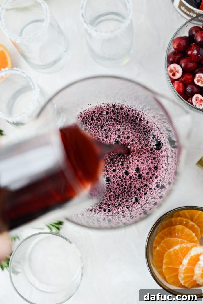 Bright & Bubbly Christmas Mornings 8 Adding pomegranate juice to the pitcher with cranberry juice