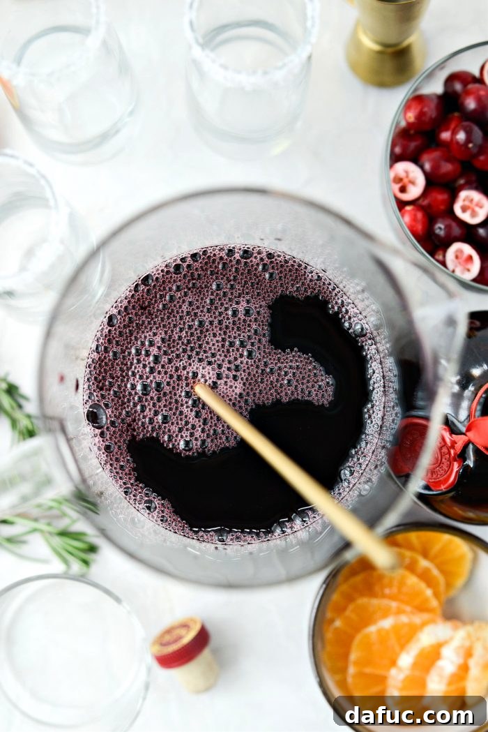 Bright & Bubbly Christmas Mornings 10 Stirring the cranberry, pomegranate, and Grand Marnier juice mixture in a pitcher