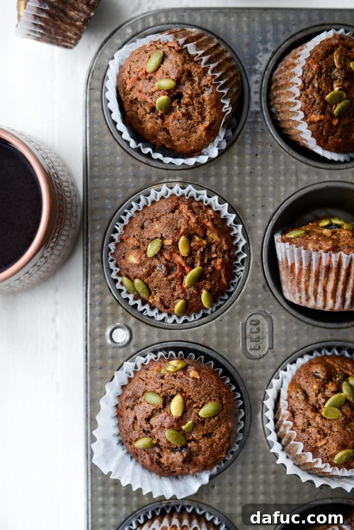 Close-up view of the interior of a Morning Glory Muffin, showing shredded carrots, apples, and walnuts.