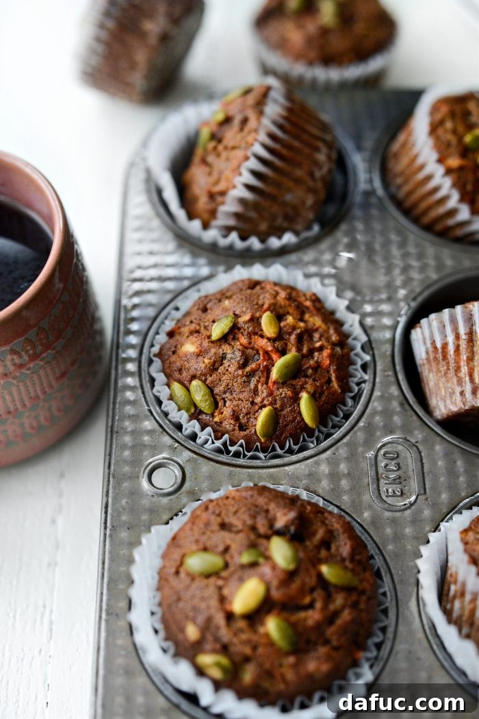 Close-up of a Morning Glory Muffin with visible shredded ingredients and pepita topping.