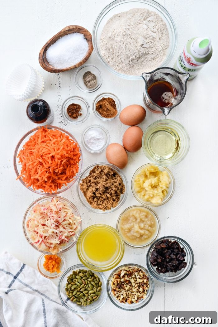 Various Morning Glory Muffin ingredients laid out on a counter, including flour, spices, fruits, and liquids.
