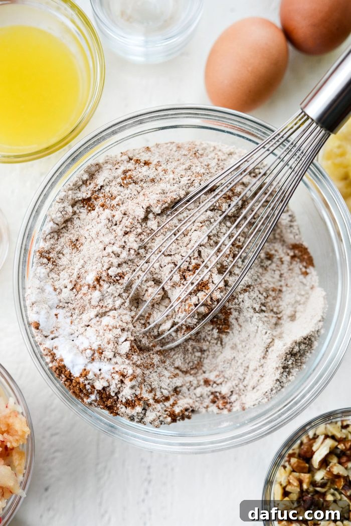 Whisked dry ingredients in a medium mixing bowl, showing a uniform light brown mixture.