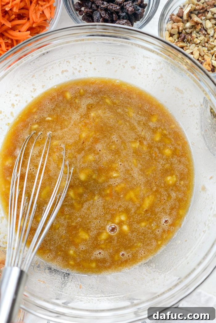 Whisked wet ingredients in a large bowl, a smooth and light brown liquid mixture.