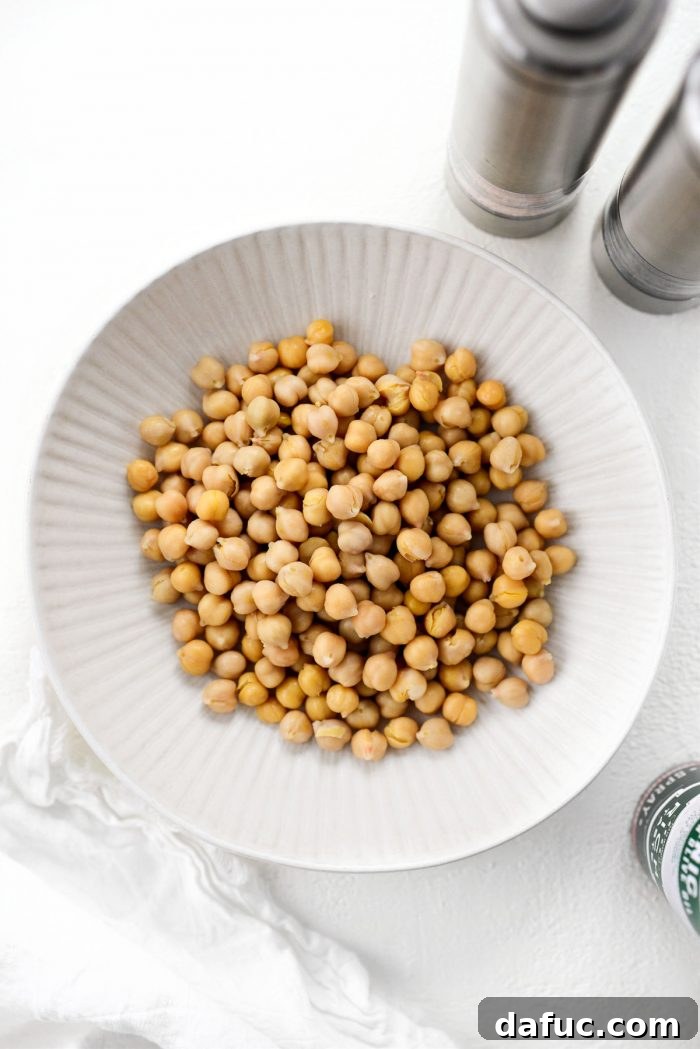 Perfectly Crisp Air-Fried Chickpeas 4 Ingredients for Crispy Air Fryer Chickpeas laid out: canned chickpeas, olive oil spray, salt, and pepper