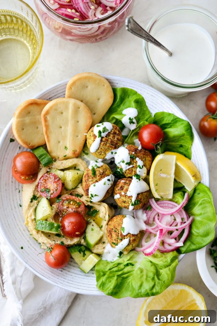 Air-Fried Falafel Perfection 17 Air Fryer Falafel in a white bowl with pickled red onion and lemon