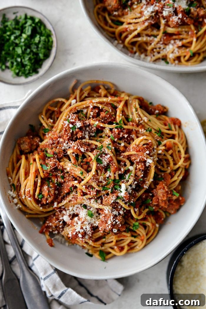 Slow Roasted Spaghetti Sauce 20 A bowl of slow baked spaghetti sauce with a fork, ready for tasting.