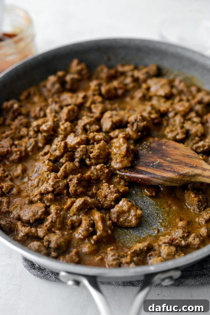 Saucy taco meat simmering in a skillet.