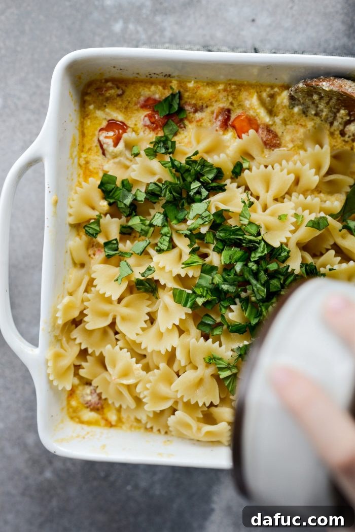 Blistered Tomato Feta Pasta 18 Adding hot cooked pasta and fresh basil to the baked feta and tomato sauce