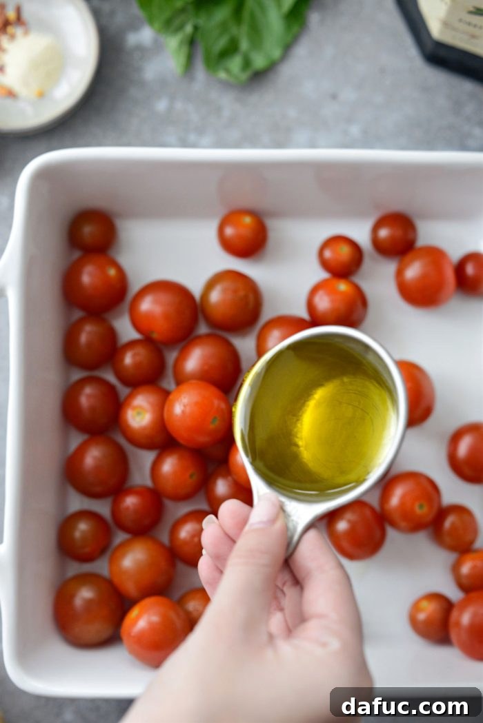Blistered Tomato Feta Pasta 7 Drizzling olive oil over cherry tomatoes in a baking dish