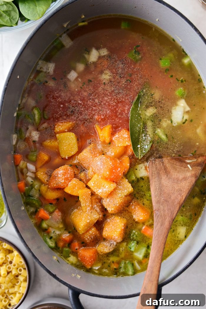 Ina Garten's Cozy Winter Minestrone 10 Broth, crushed tomatoes, squash, and bay leaf added to the pot