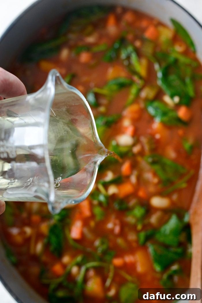 Ina Garten's Cozy Winter Minestrone 17 Dry white wine being poured into the soup