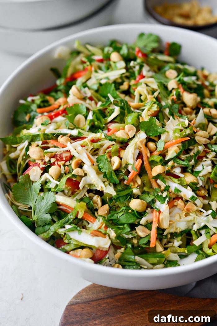 Zesty Thai Cabbage Slaw 3 Side view of Thai Cabbage Salad in a white bowl, showing layers of vegetables.