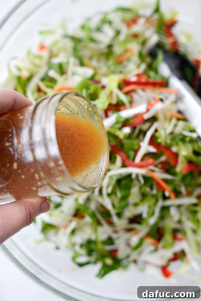Zesty Thai Cabbage Slaw 8 Pouring the Thai dressing over the prepared salad ingredients.