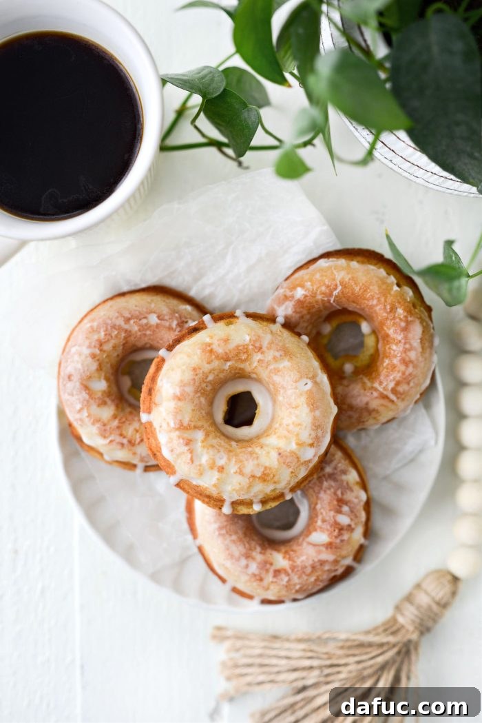 Freshly baked Glazed Buttermilk Cake Doughnuts on a wire rack, ready to be enjoyed.