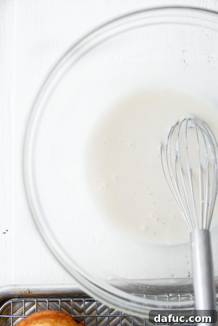 Ingredients for vanilla glaze: sifted powdered sugar, milk, and vanilla extract in a bowl.