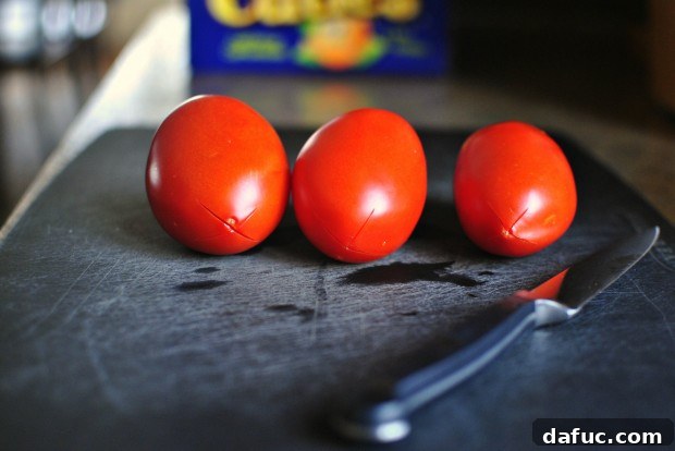 Hearty Plant-Based Lentil Stew 7 Scoring an 'X' on the bottom of a Roma tomato