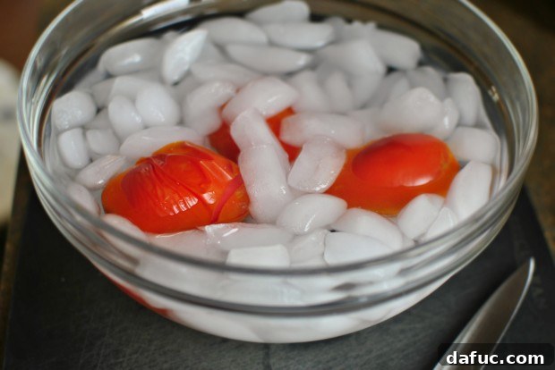 Blanched tomatoes being transferred to an ice bath