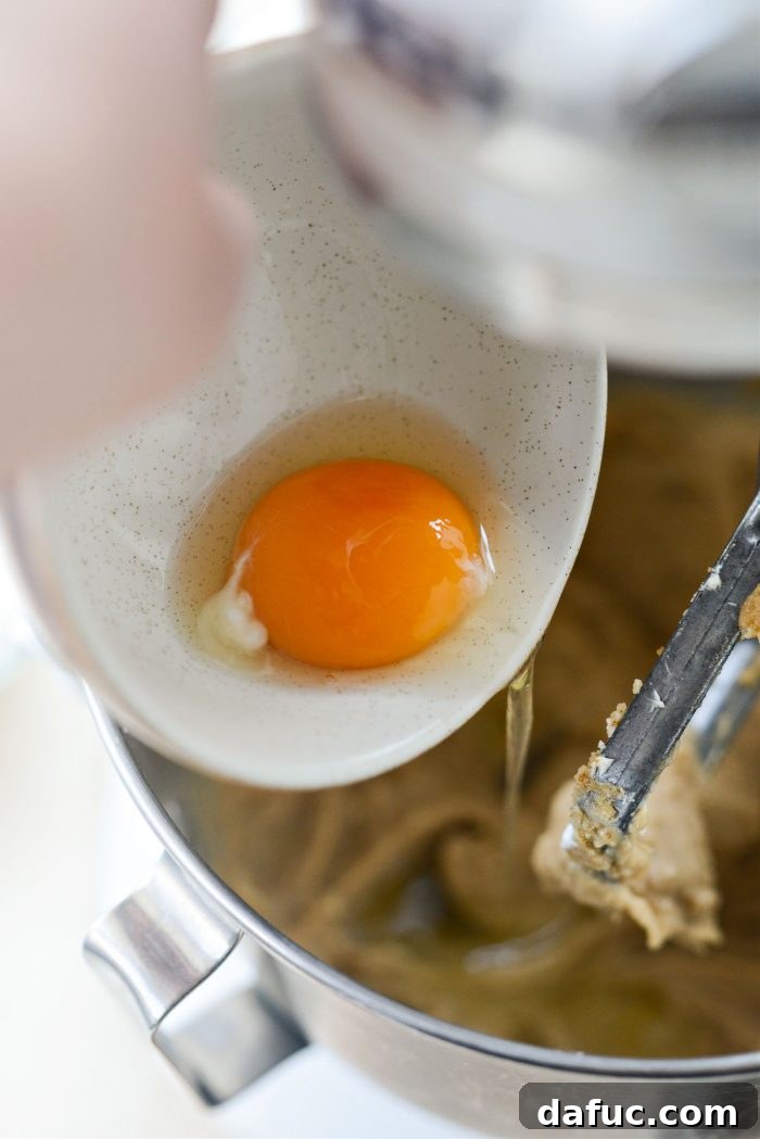 Emerald Isle Whiskey Cake 13 Adding eggs one by one to the cake batter in the mixer