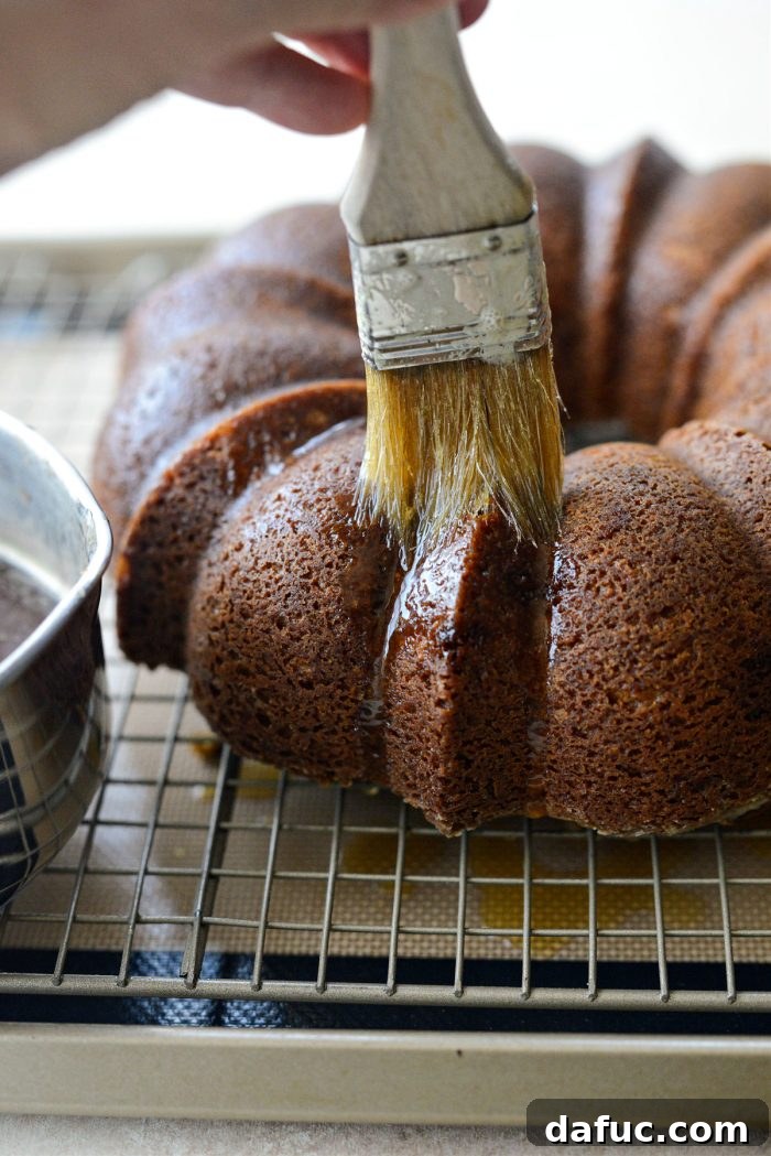 Brushing the warm Irish whiskey glaze over the cooled bundt cake
