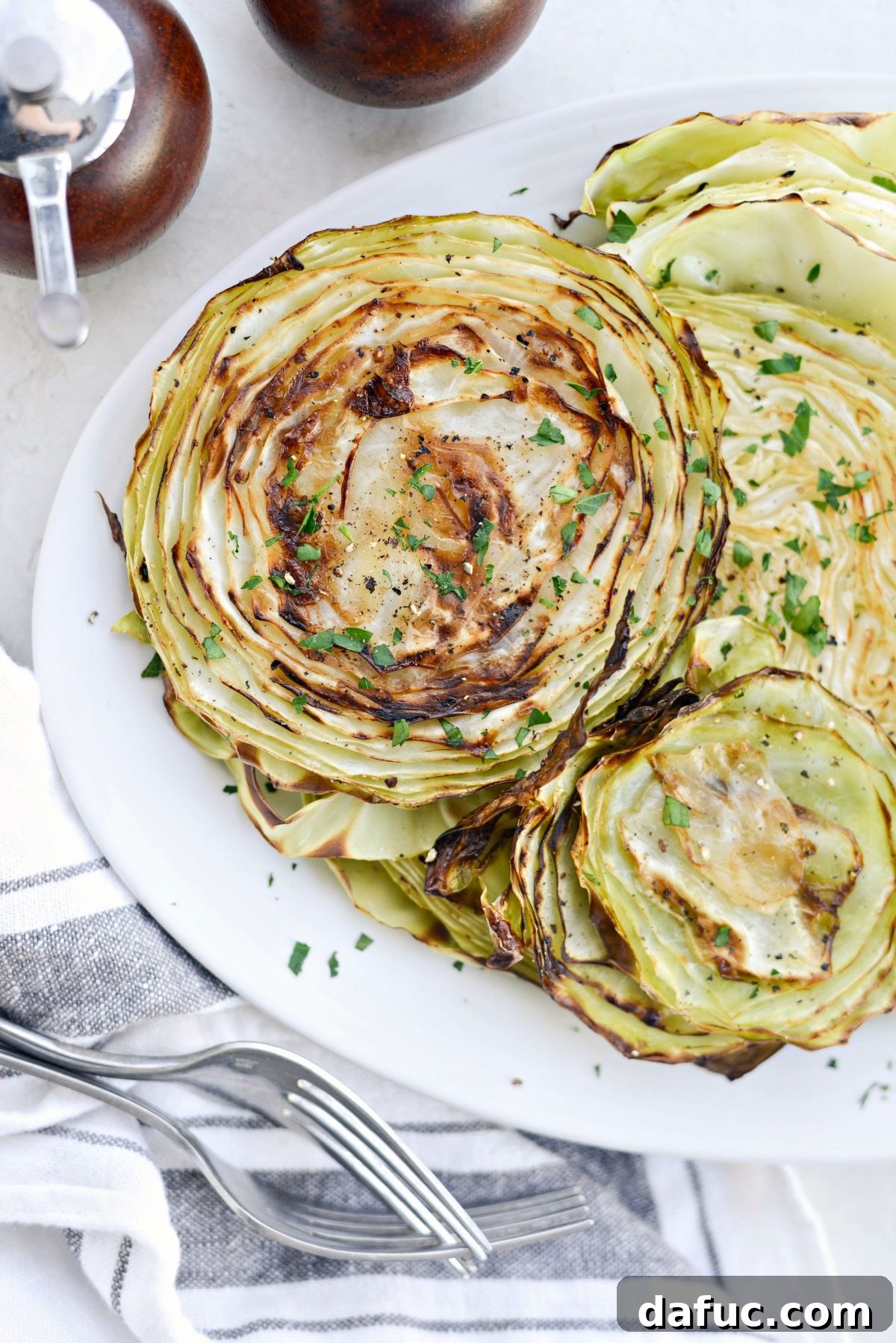 25+ Delicious St. Patrick's Day Recipes 19 Golden brown Roasted Cabbage Steaks garnished with fresh herbs, served as a side